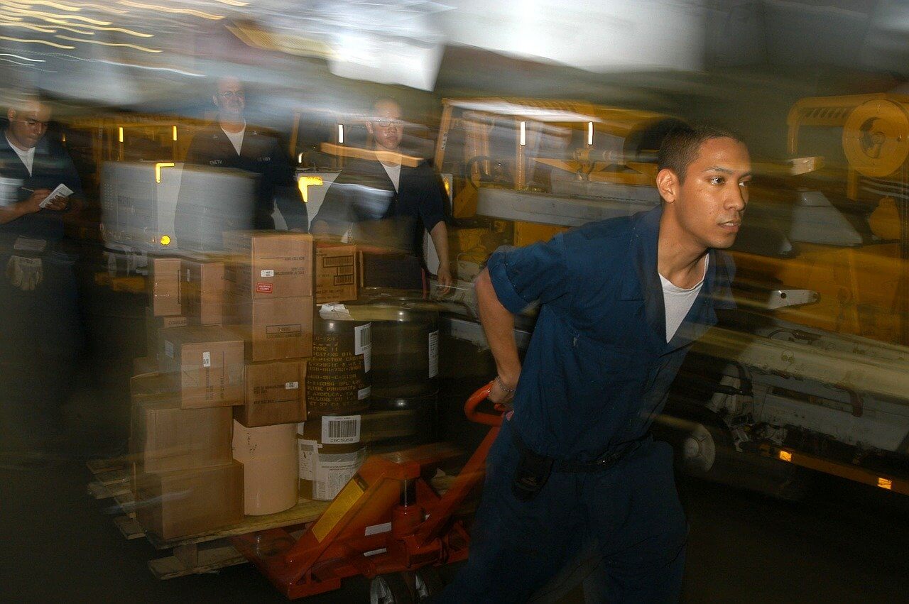person pulling supplies with pallet jack
